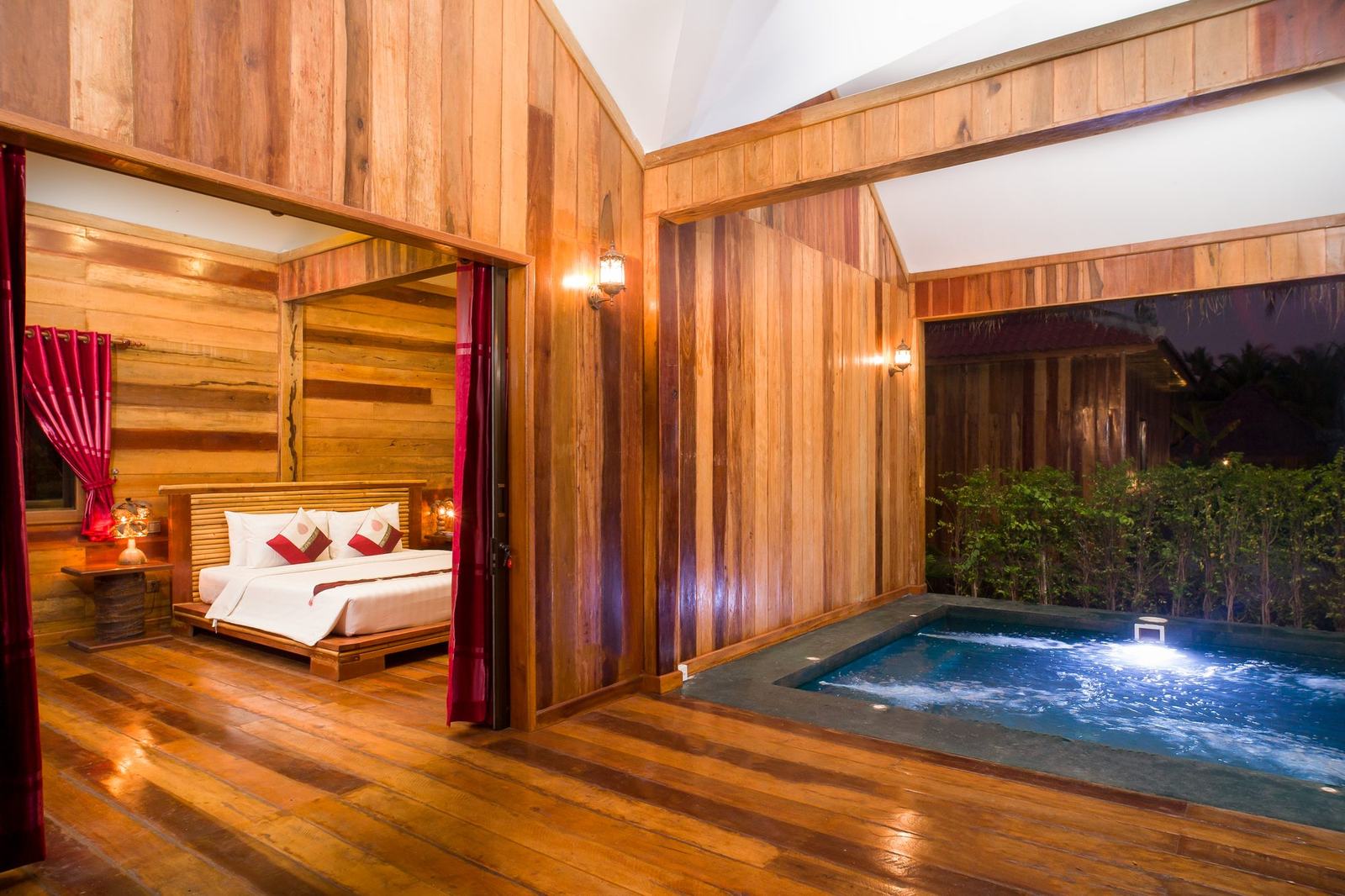 Jacuzzi bungalow bedroom opening onto its lit jacuzzi