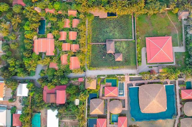 Tiled roofs, gardens and pools of the lodge seen from above