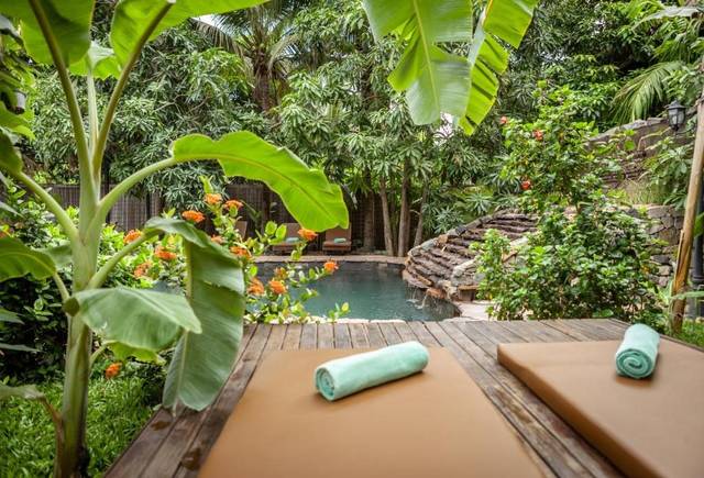Sun deck by the garden pool among banana trees