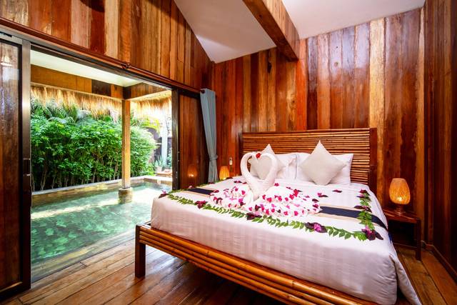 Pool villa bedroom opening onto the private pool